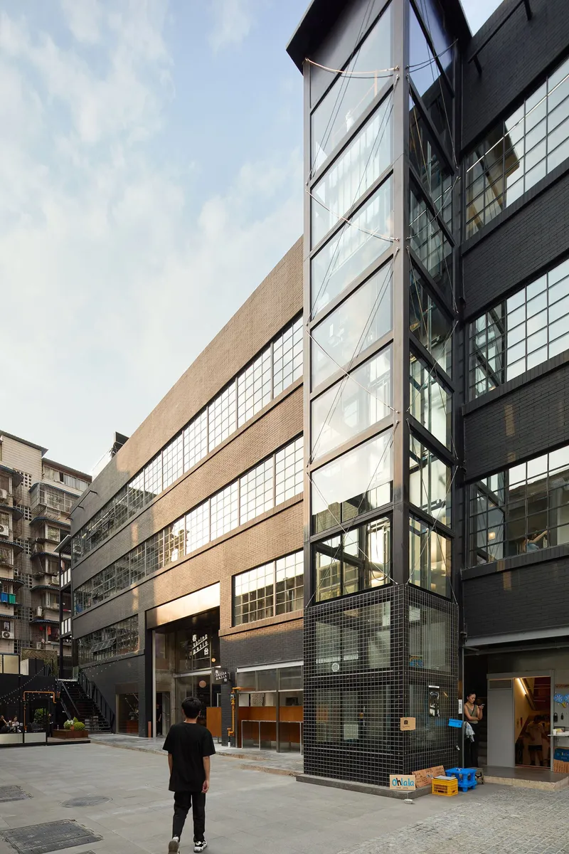 Street facade with glass block ribbon window and angled metal awning at dusk