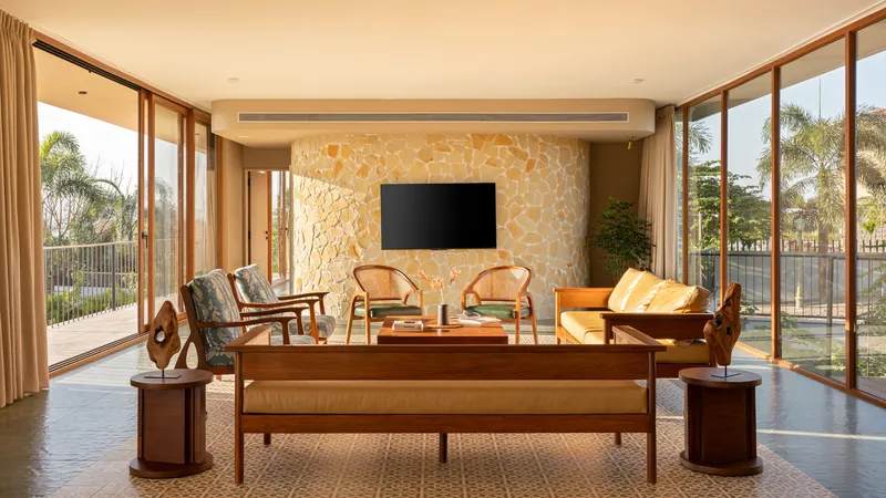 Living room featuring a textured stone accent wall with floor-to-ceiling glazing on both sides
