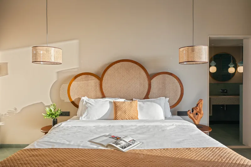 Bedroom with circular cane headboard panels and doorway leading to the ensuite bathroom