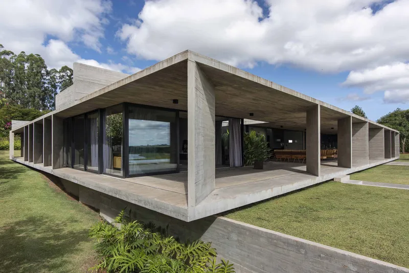 Corner view of the pavilion showing concrete columns, deep overhang and full-height glazing