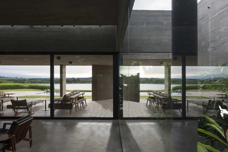 Living area with sliding glass doors opening to a terrace and lake view under overcast skies