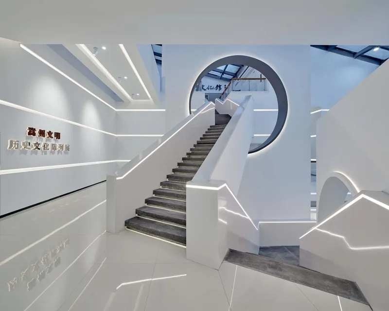 Entry lobby featuring a sculptural staircase with edge-lit handrails and skylights above