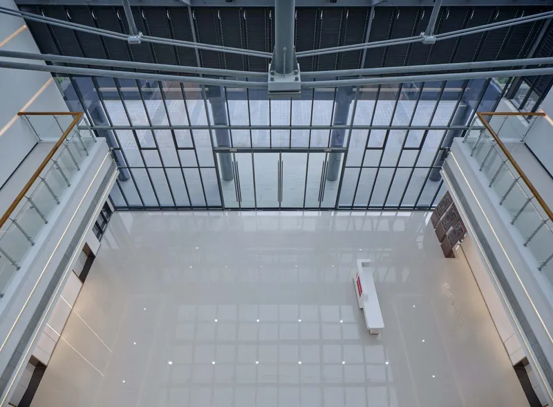 Overhead view of the central atrium with a glazed roof and white tiled floor below