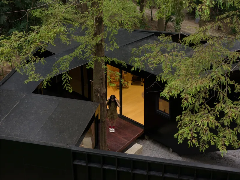 Overhead view of a figure standing at the threshold between timber deck and illuminated interior