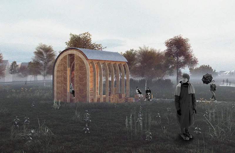Side view of the open straw structure with corrugated metal roof among wildflowers and trees