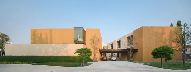 Street view of the peach and cream facade with central carport beneath a dark sky