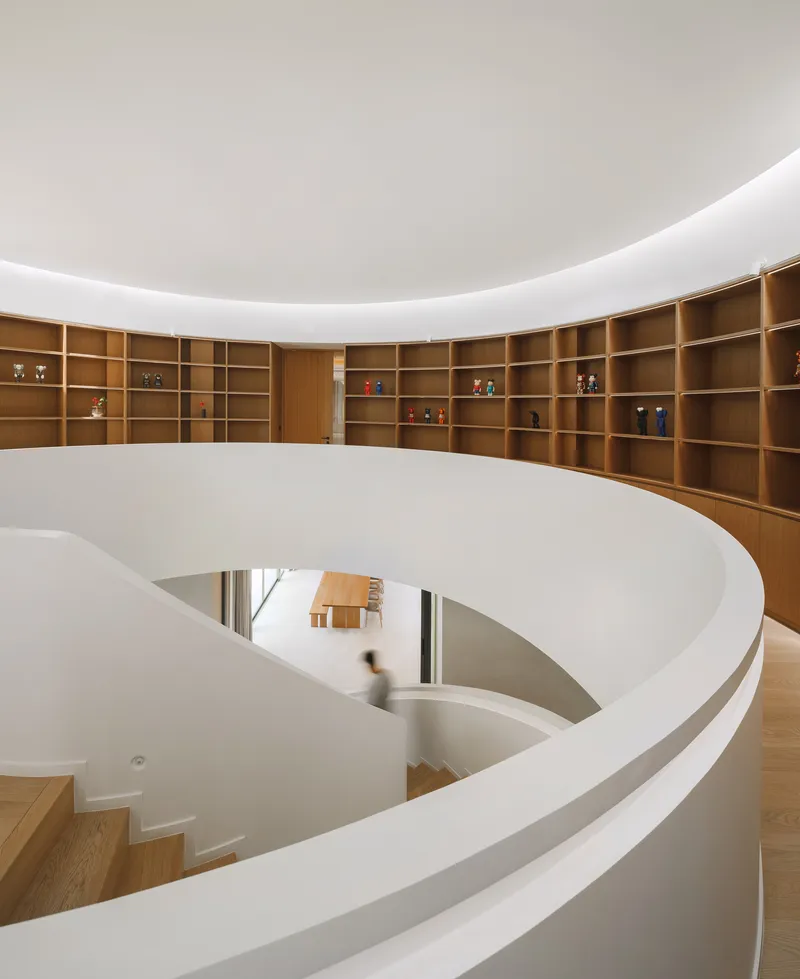 Top-down view of the spiral staircase with timber shelving along the curved wall