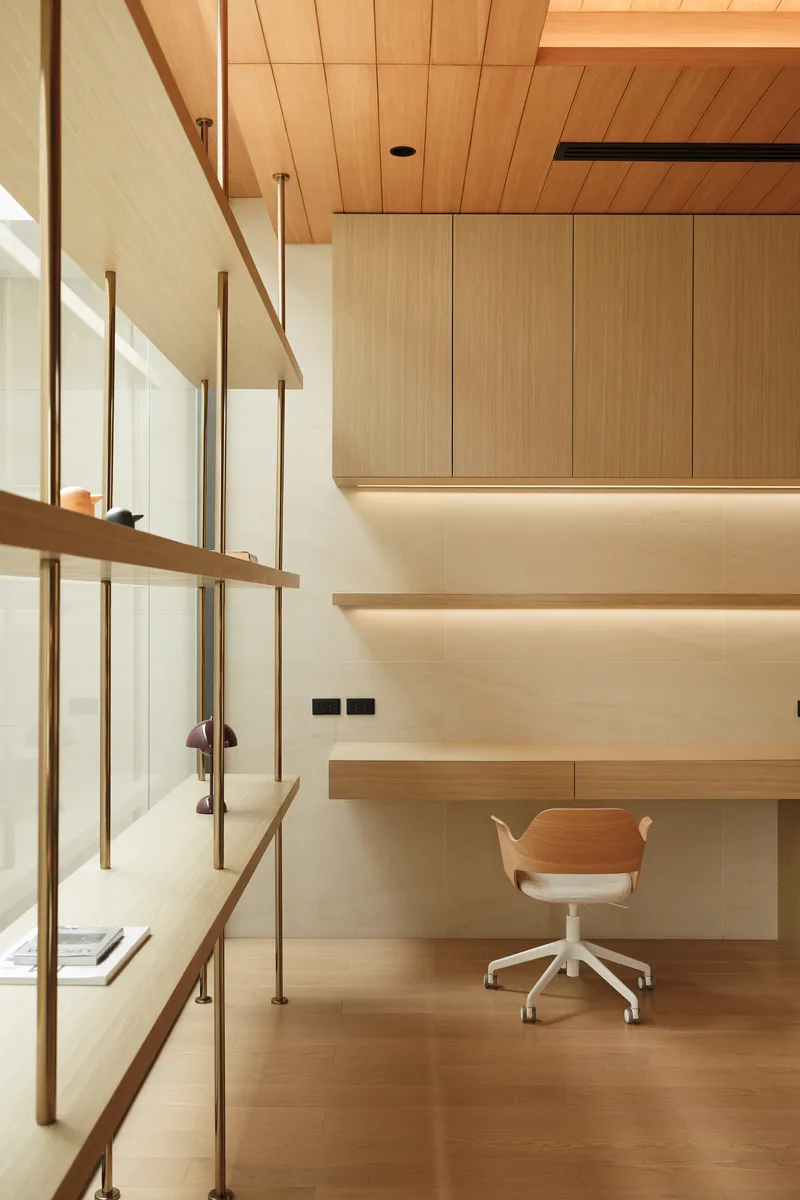 Double-height workspace with timber shelving, desk below upper storage cabinets and wood ceiling
