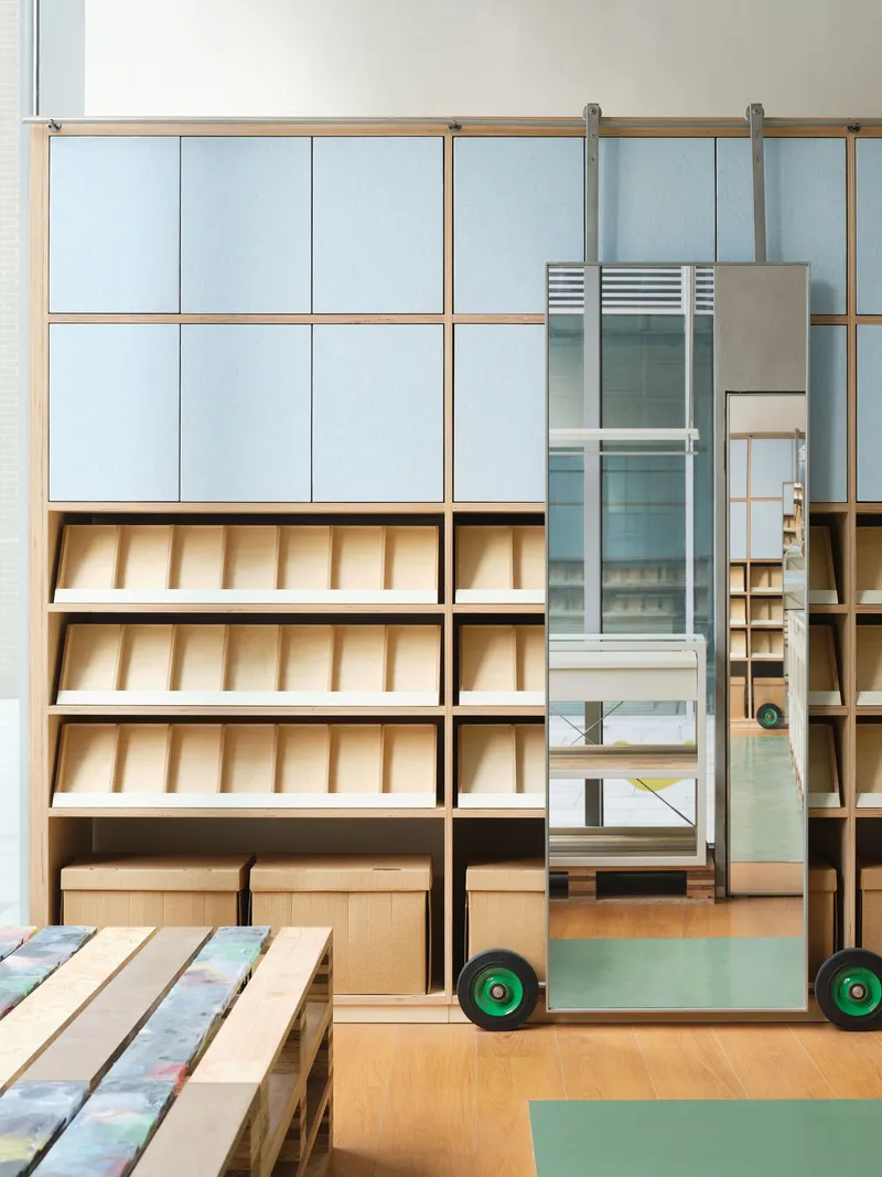 Sliding ladder on rails beside tiered display shelving with pale blue cabinet doors and timber framing