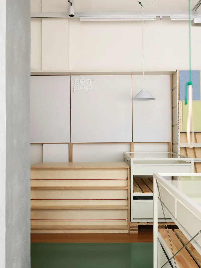 Timber bench with red edge detail beneath white sliding panels and pendant light