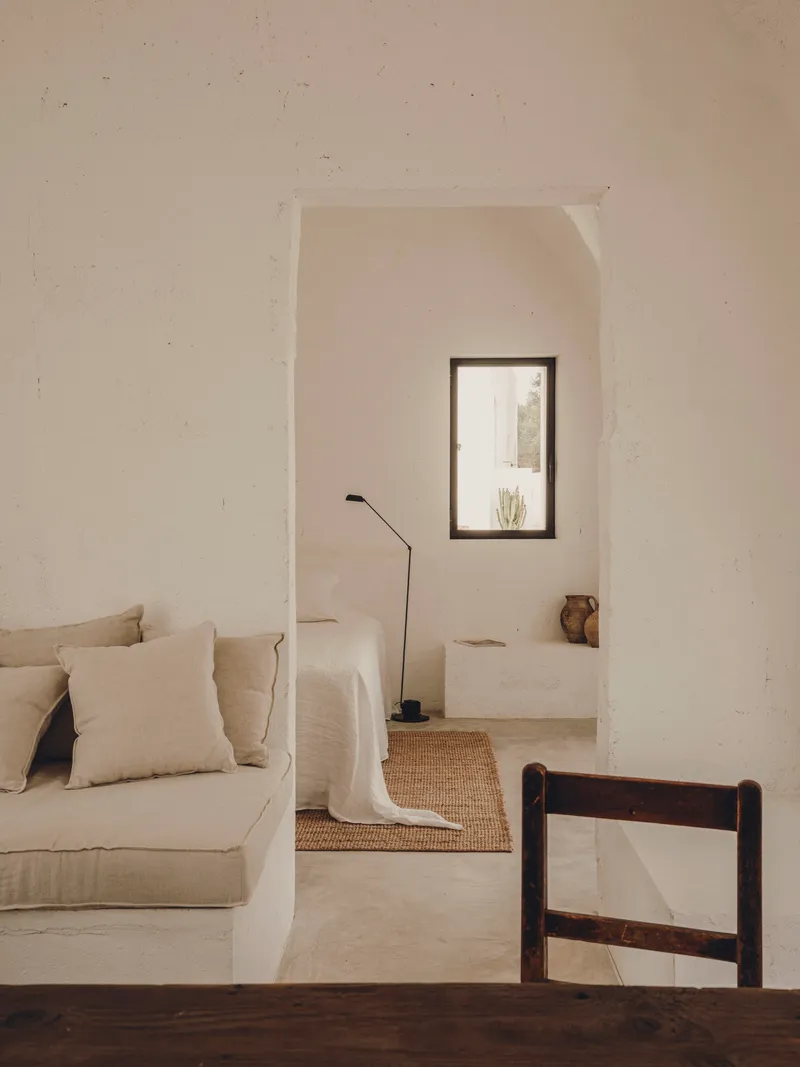 Arched doorway framing a vaulted alcove with portrait window and polished concrete floor in afternoon light