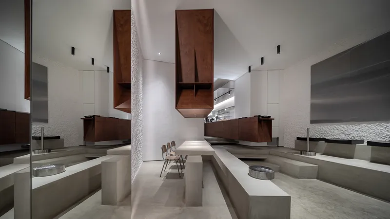 Sunken seating area with concrete benches and walnut cabinetry suspended above a double-height space