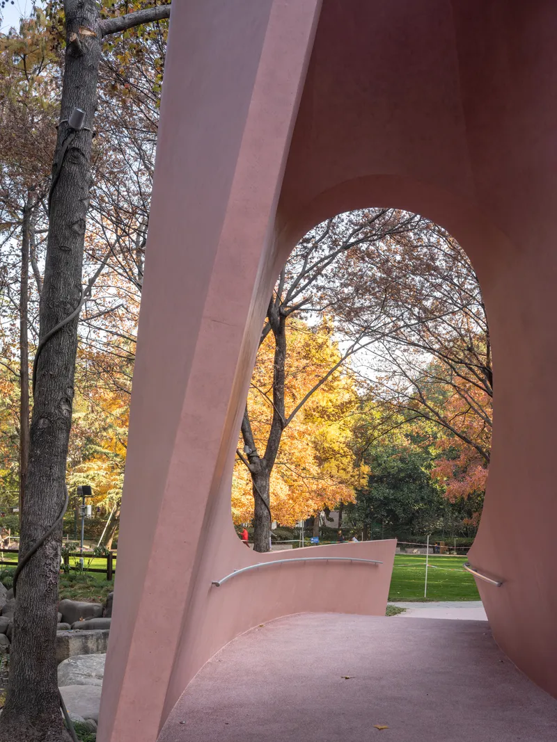 View through the arch opening framing park trees in yellow and orange autumn colors