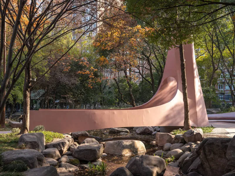 Side elevation of the sculptural form extending horizontally over a boulder-filled creek bed