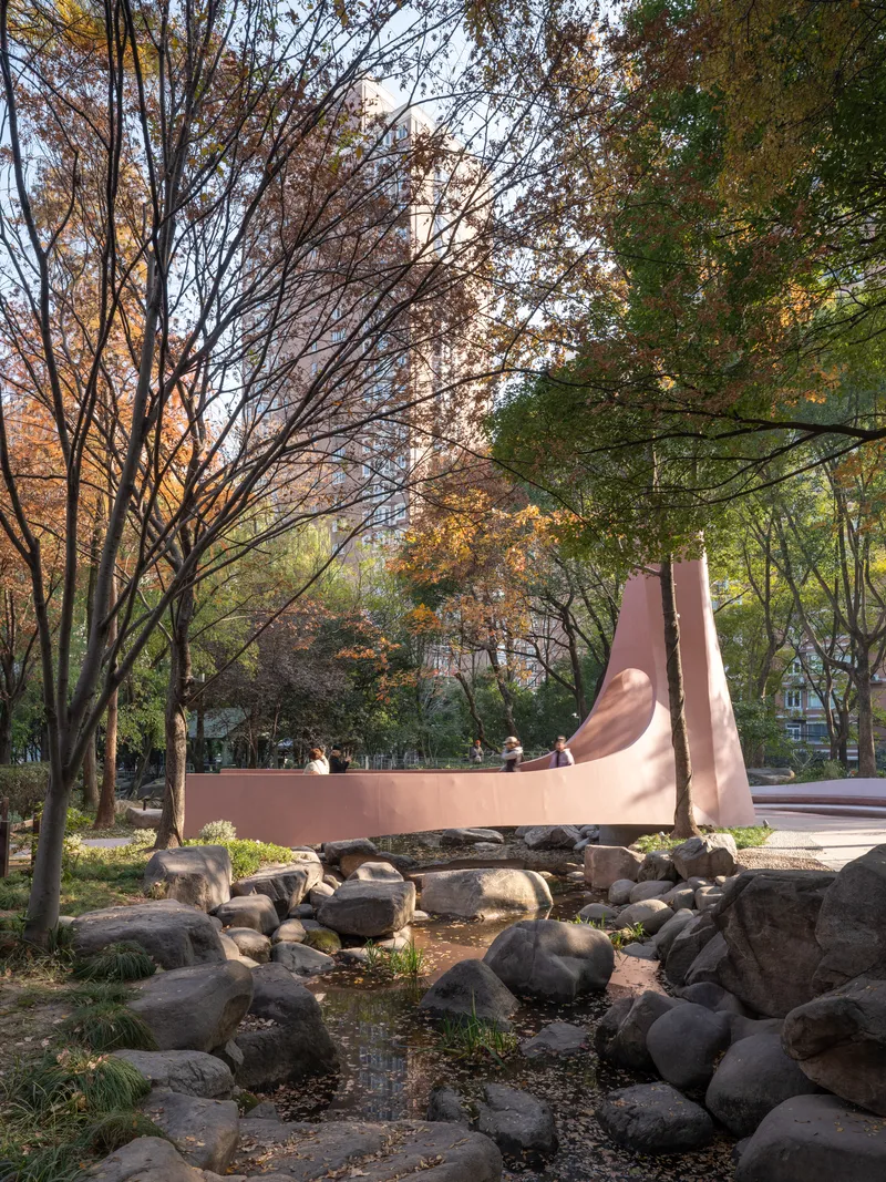 Long view of the ribbonlike footbridge crossing over boulders and water in afternoon light