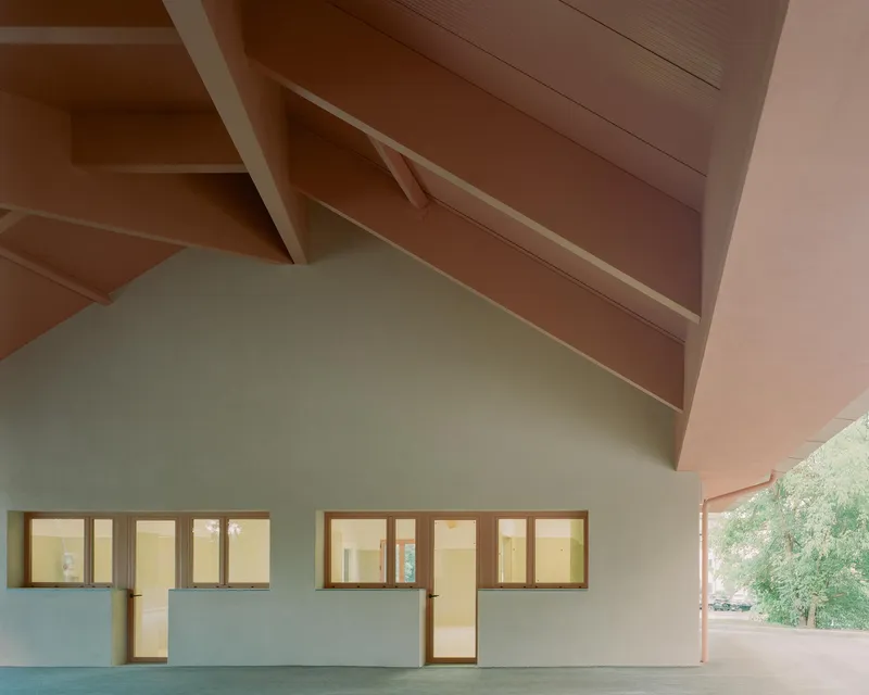 Interior view of the vaulted timber ceiling above clerestory windows and pale green partition wall