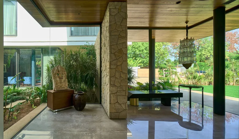 Interior courtyard with planted bed, stone column and polished concrete floor under timber soffit