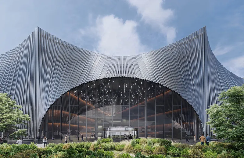 Arched entrance with perforated metal canopy and glazed opening beneath a saddle-shaped ribbed roof under blue skies