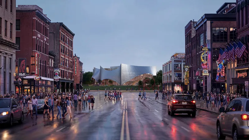 View down a wet street at dusk with pedestrians and cars facing the illuminated sculptural facade