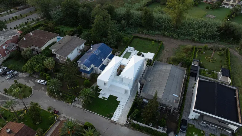 Aerial view of the white geometric volumes arranged around internal courtyards in a suburban neighborhood