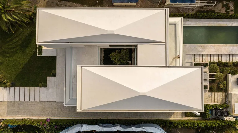 Aerial view of white cantilevered terraces with triangular shadow patterns and surrounding landscaping