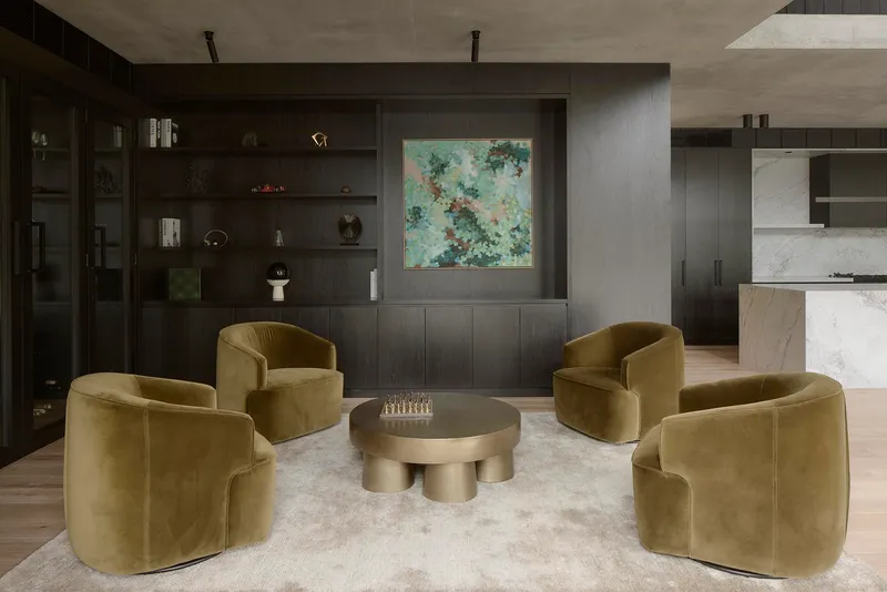 Sitting area with dark timber shelving, concrete ceiling and view through to marble kitchen