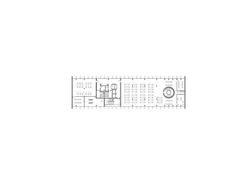 Floor plan drawing showing a long rectangular volume with workstations and a circular feature at one end