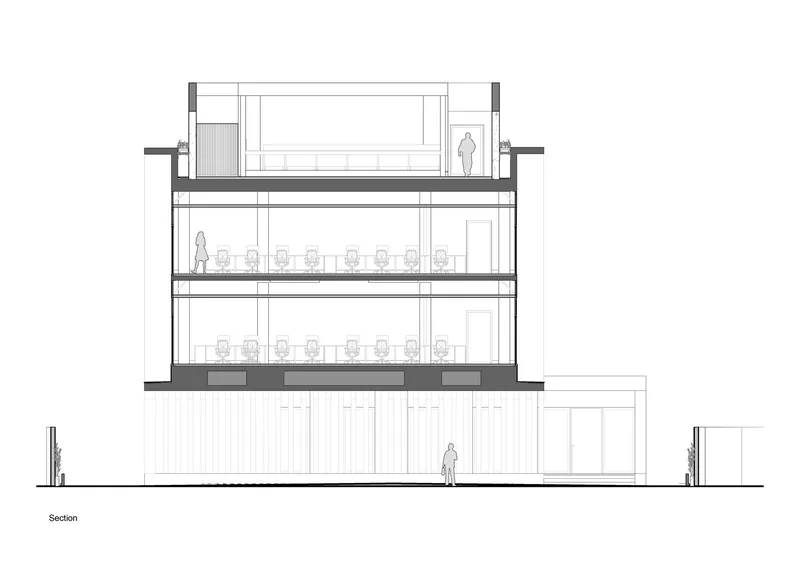 Section drawing through a three-story volume showing workspaces with rows of desks and a pedestrian at ground level