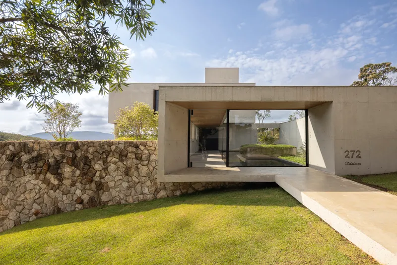 Cantilevered concrete entry bridge framing a view through to the interior courtyard beyond