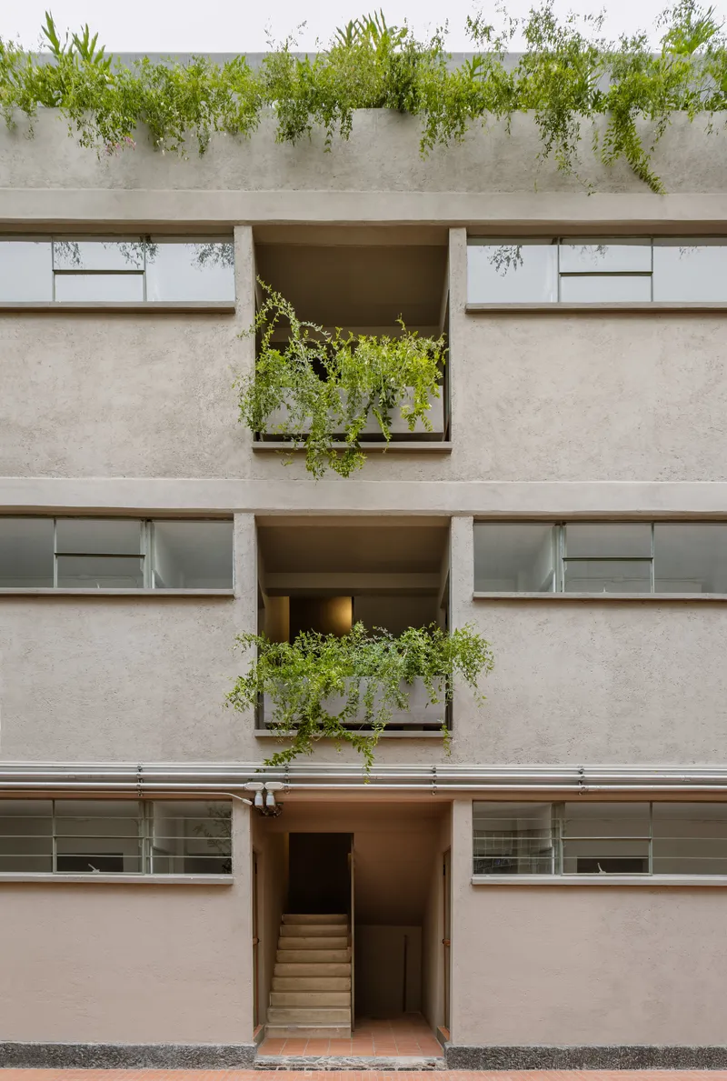 Facade elevation showing three stacked balconies with planted boxes and a central stair entry