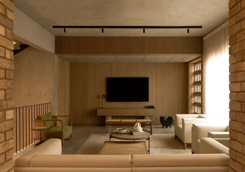 Living space with timber slat wall and perforated brick screen flanking a bright window