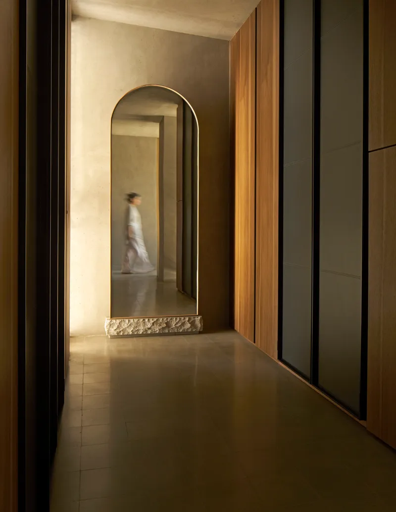 Corridor with arched opening, timber paneling and a figure passing through in motion blur
