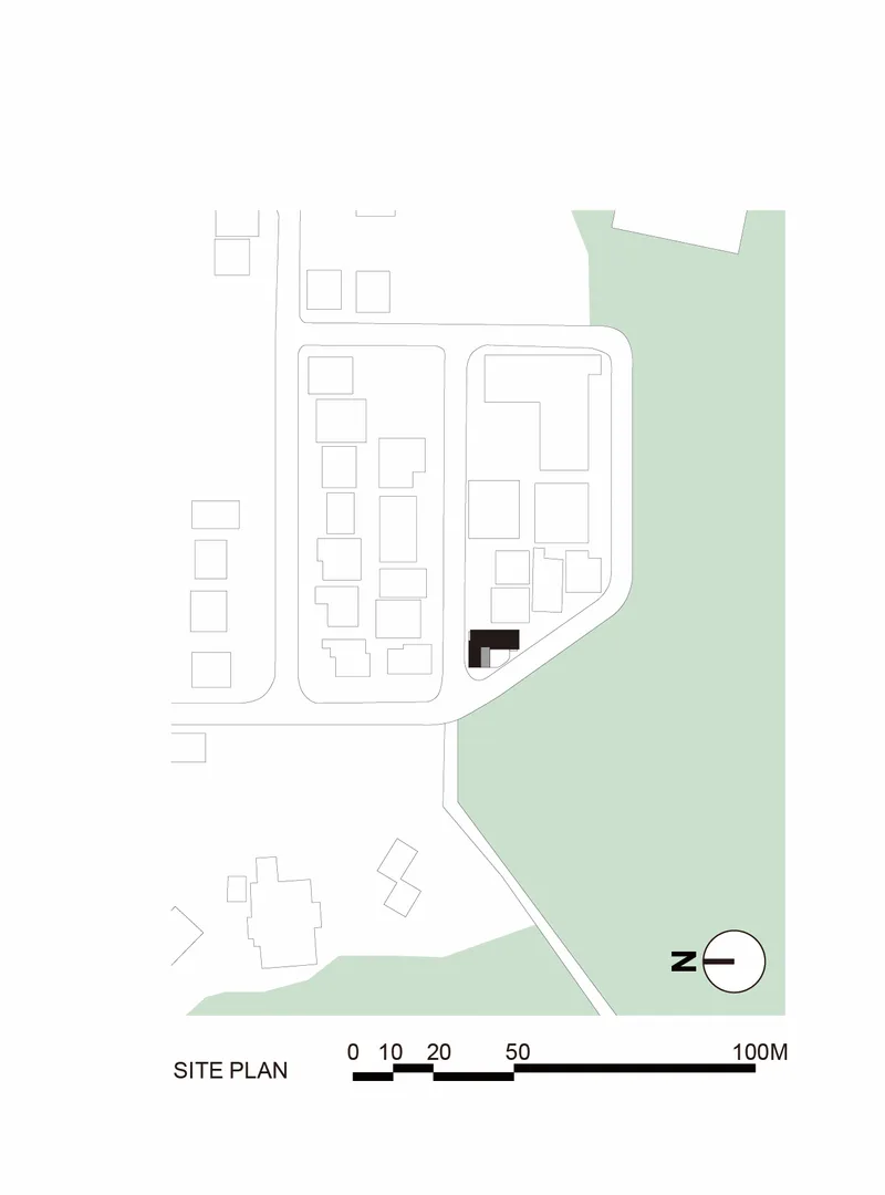 Site plan drawing showing building footprint in residential neighborhood adjacent to green waterfront area