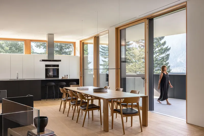 Open dining area with timber table and sliding glass doors opening to a terrace