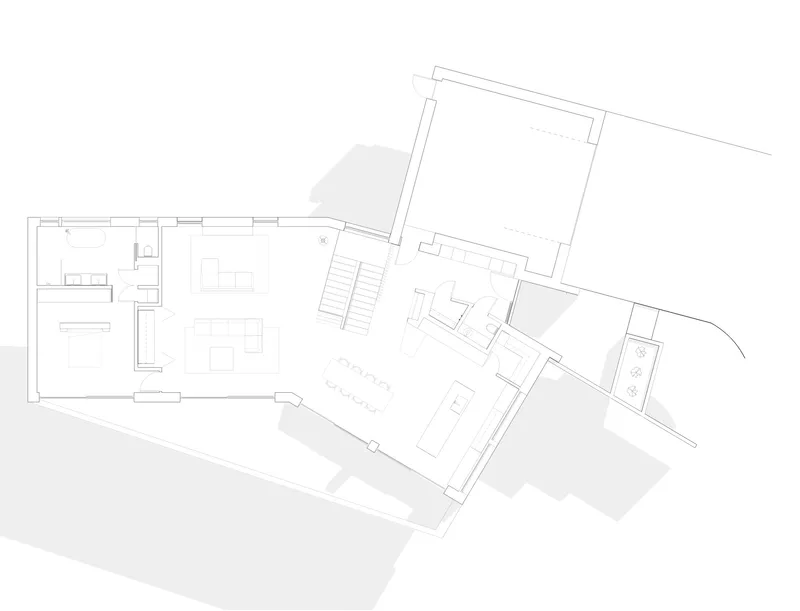 Floor plan drawing showing angled volumes connected by a central staircase and open living area