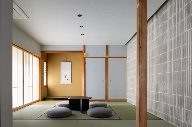 Tatami room with sliding screens and timber column alongside a vertical slatted partition wall