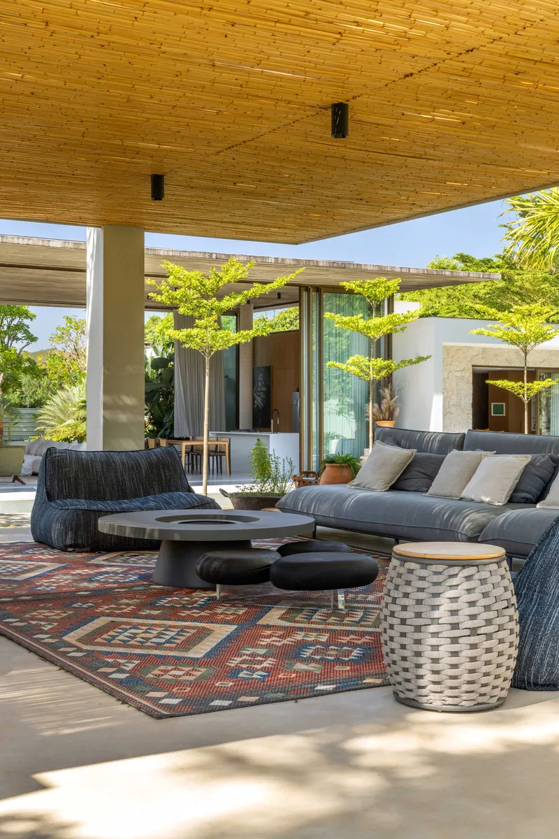 Covered seating area with timber plank ceiling and concrete floor beneath the broad eave