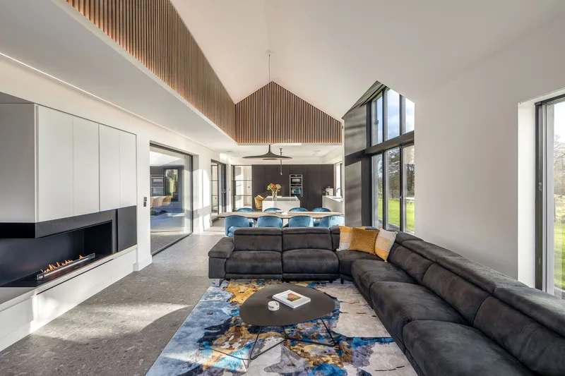 Open-plan living space with timber slat ceiling feature and full-height glazing to garden