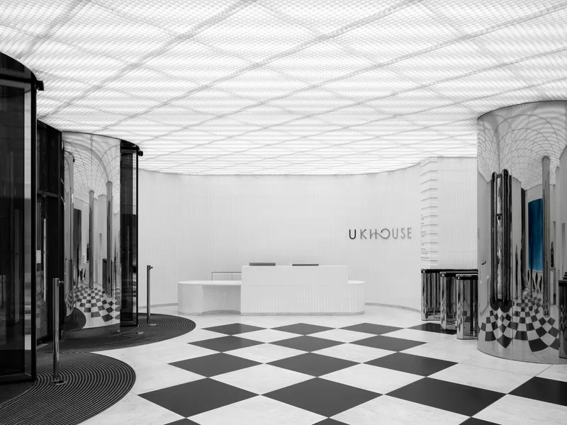 Reception area with undulating perforated ceiling and black and white chequered floor