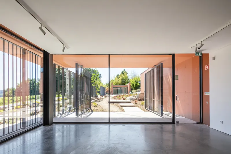 Interior space with polished concrete floor and floor-to-ceiling glass doors opening to the screened courtyard beyond