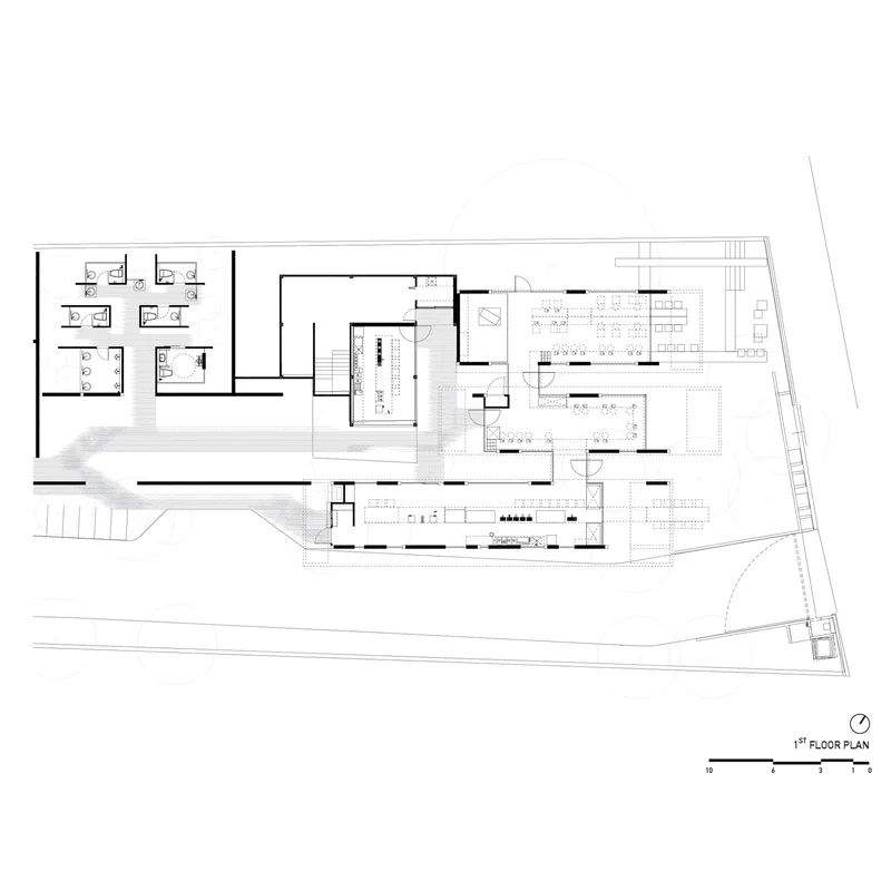 First floor plan drawing showing dining areas, kitchen, office spaces, and a curved outdoor terrace