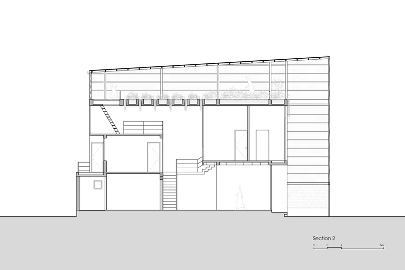 Section drawing showing multi-level interior spaces with stairs connecting volumes beneath a flat roof