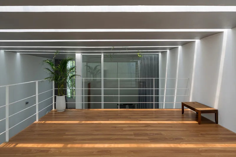 Upper level mezzanine with timber flooring, white horizontal railings, and recessed linear ceiling lights