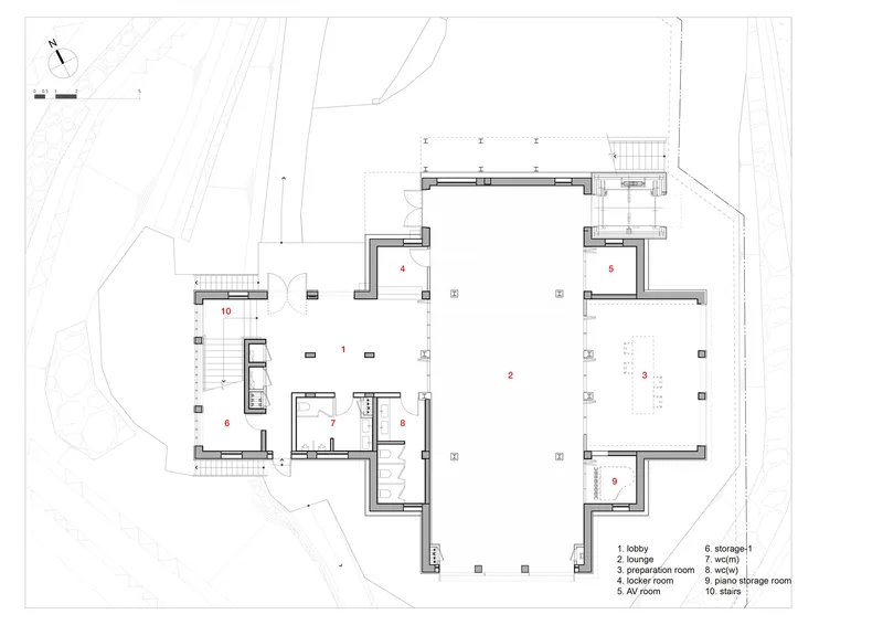 Floor plan drawing depicting a large central lounge space with surrounding service rooms and curved site boundary