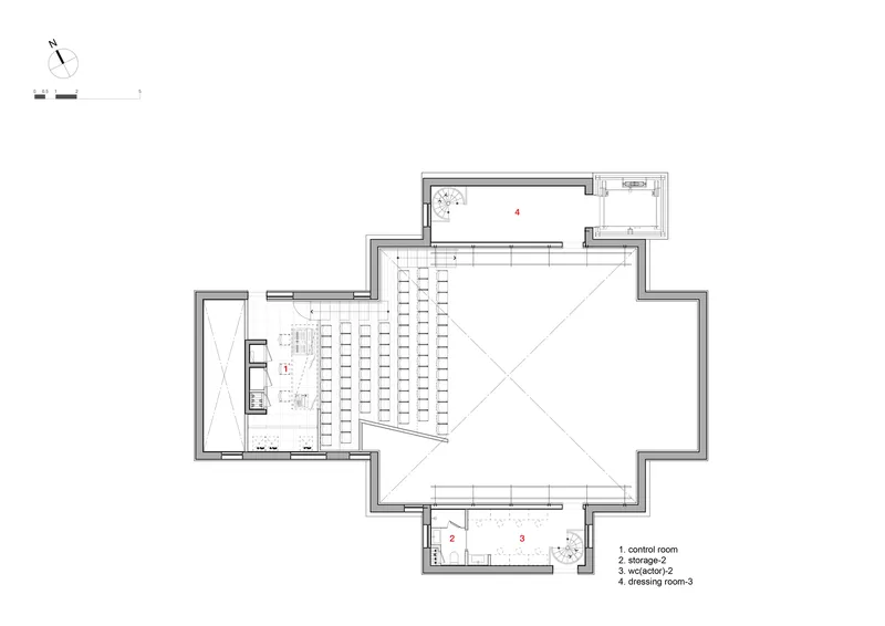 Floor plan showing an auditorium with angled seating rows and adjacent backstage and support spaces