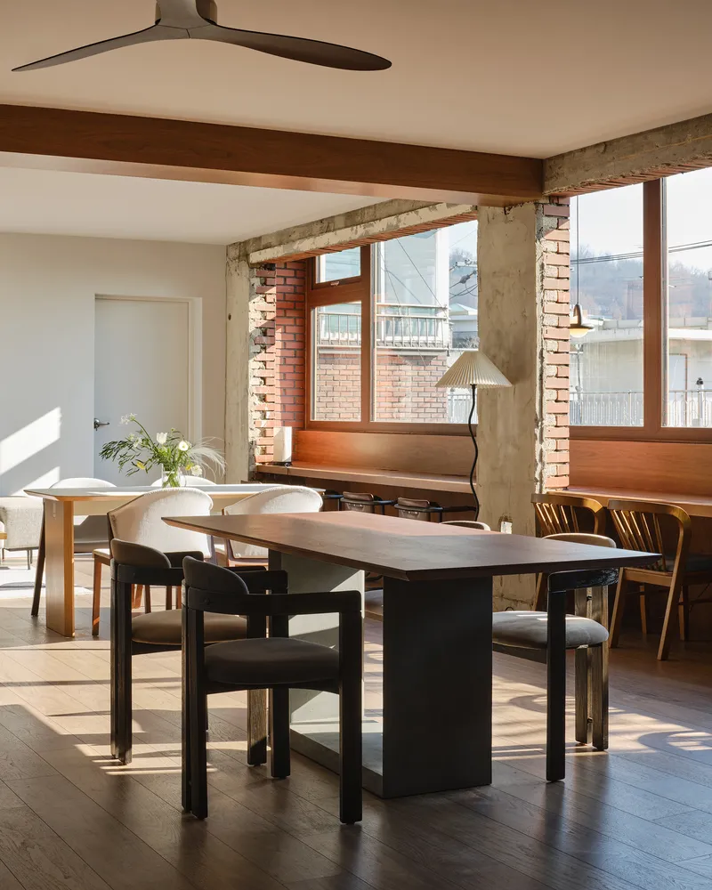 Dining area with exposed brick piers and timber-framed window seat in morning light