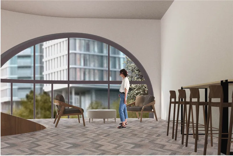 Second-floor lounge with bookshelves, warm wood flooring, and arched windows for reading and reflection.