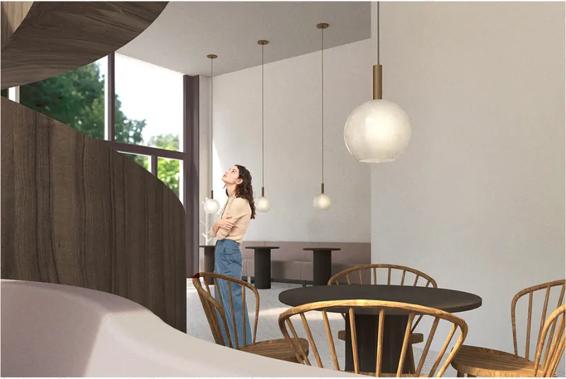 Curved wooden staircase and pendant lighting create a fluid transition through the main cafe interior.