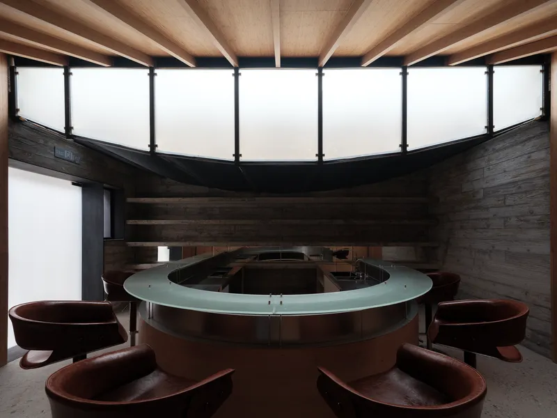 Circular clerestory window above a round communal bathing basin surrounded by timber tubs