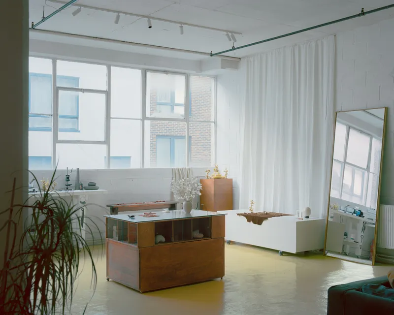 Open studio space with yellow resin flooring and large gridded windows framing brick buildings
